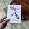 ’Cheers To Your Next Adventure’ Champaign Card